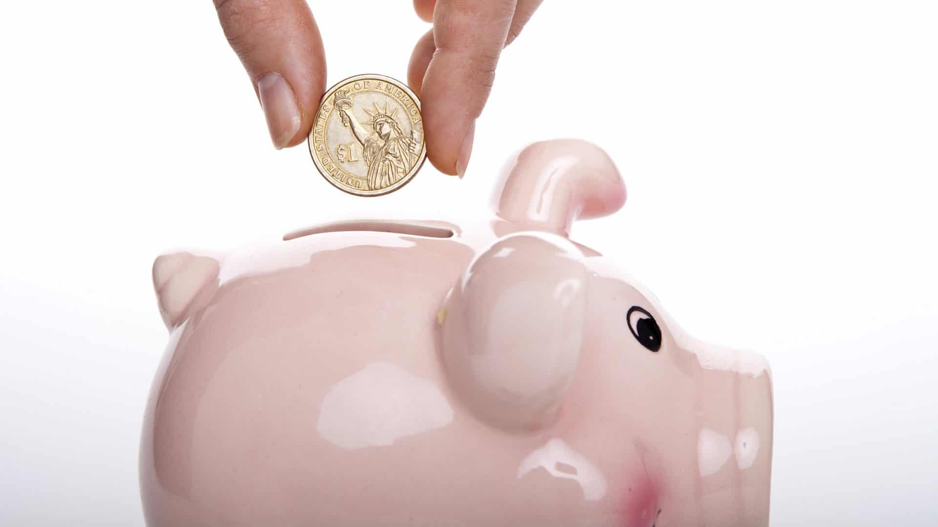 Sparschwein, in das eine Euro-Münze geworfen wird steht für solides Sparen mit Produkten wie dem comdirect Festgeld