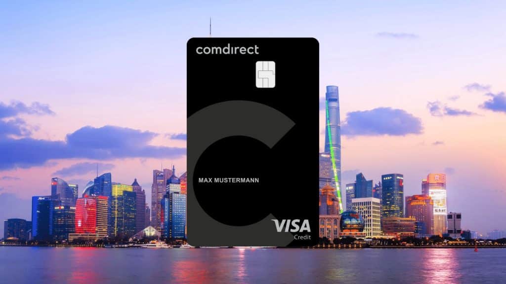 Comdirect Visa Kreditkarte im Vordergrund, im Hintergrund die Skyline einer Stadt bei Sonnenuntergang