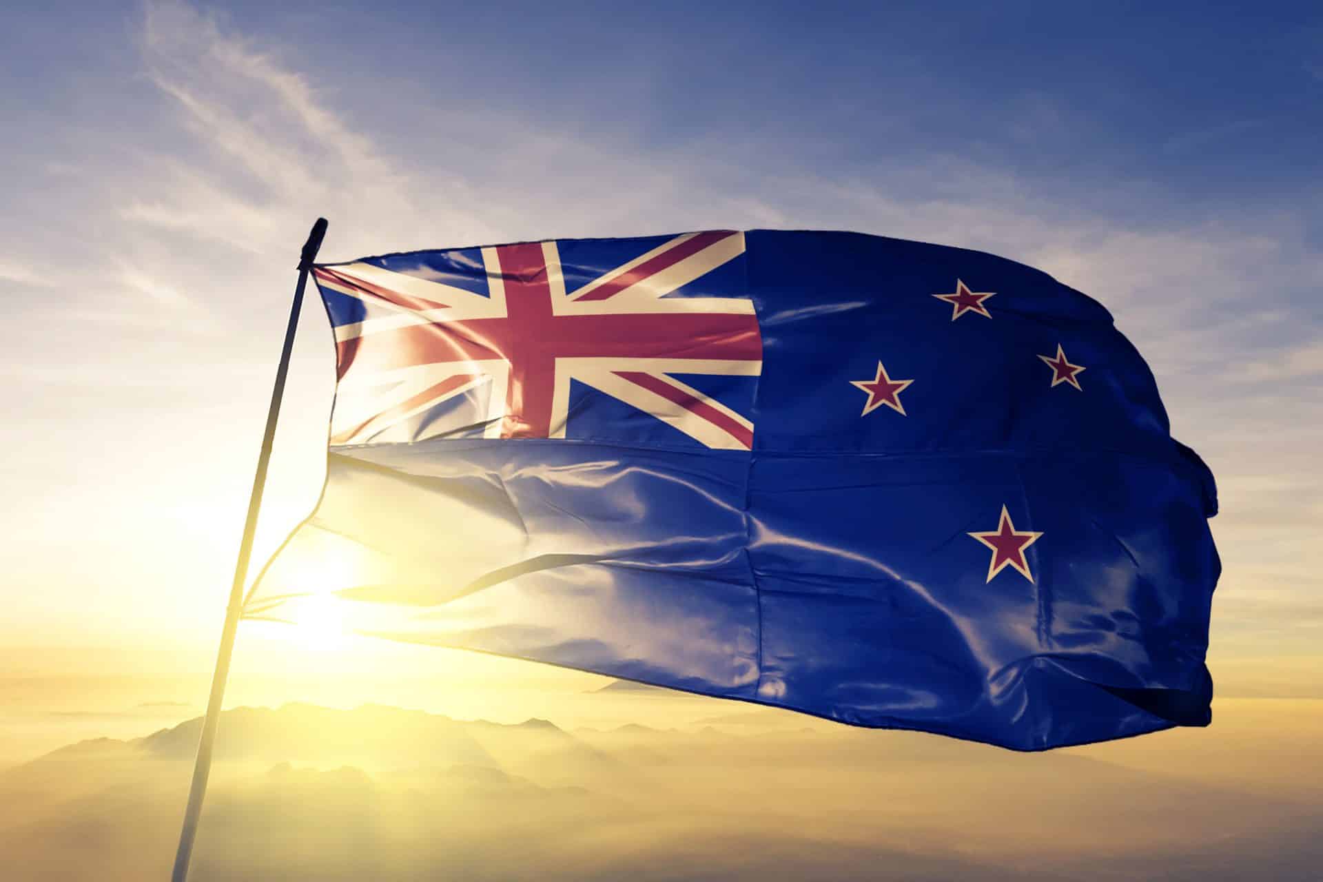 New Zealand Zealander Flag Textile Cloth Fabric Waving On The Top Sunrise Mist Fog