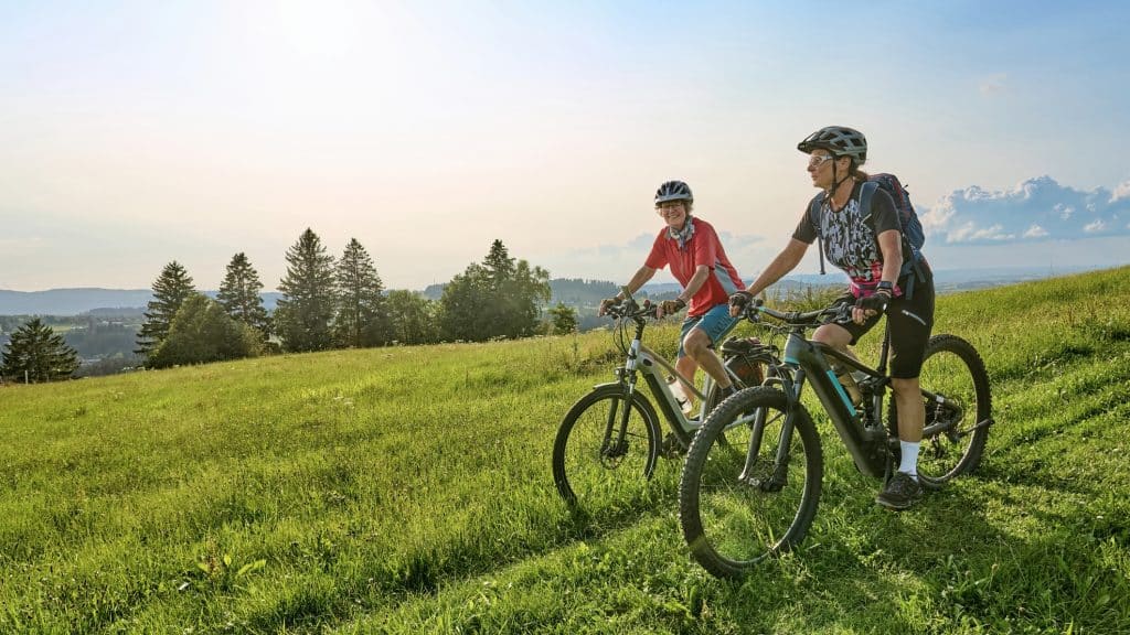 Zwei Seniorinnen radeln mit E-Bikes in den deutschen Alpen