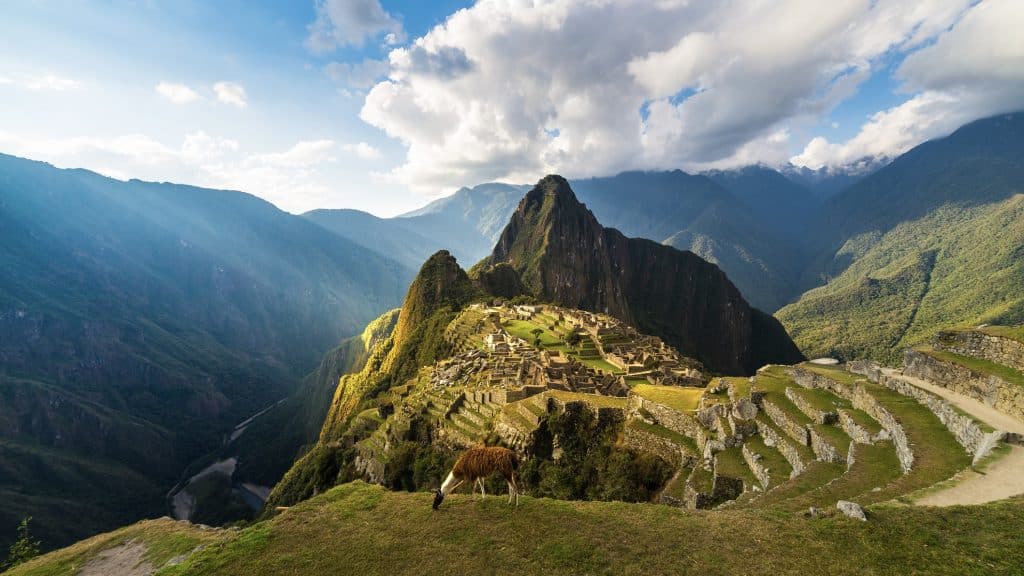 Der Machu Picchu im Vordergrund, im Hintergrund die bergige Landschaft Perus