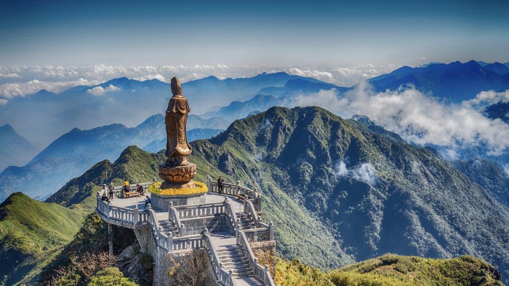 The Grand Statue Photo Of Goddess Guan Yin Above The Clouds With Scenic Misty Mountain View As Background, At Fansipan Peak,Vietnam