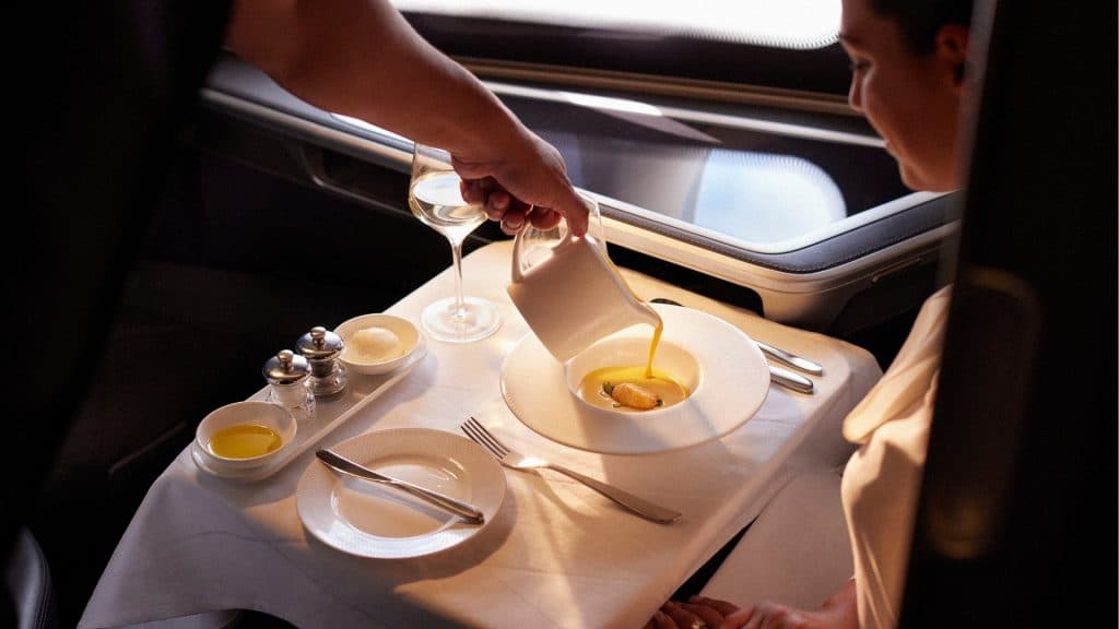 British Airways A Customer Enjoying A Meal In First Class