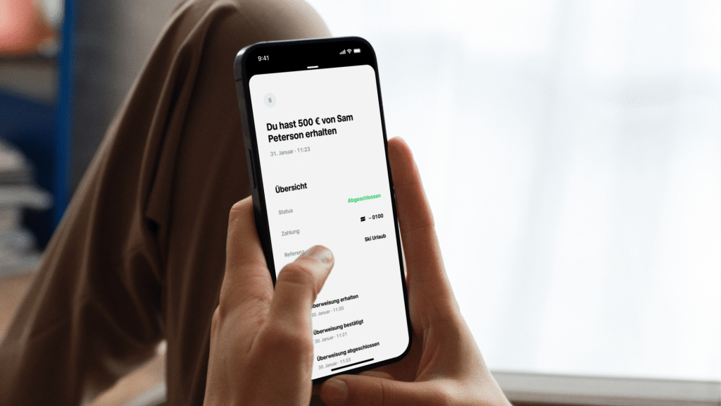 Person haelt Handy mit Trade Republic App in der Hand