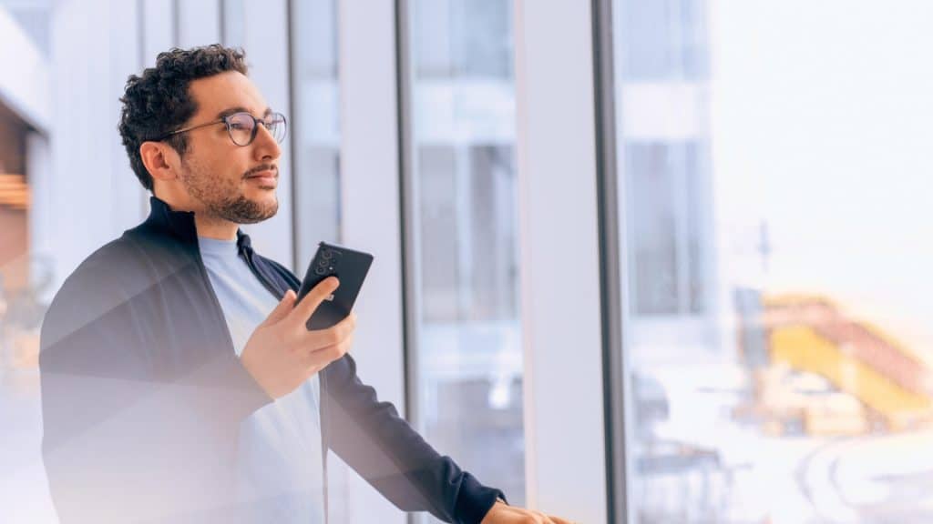 Man With Glasses Holding a Smartphone