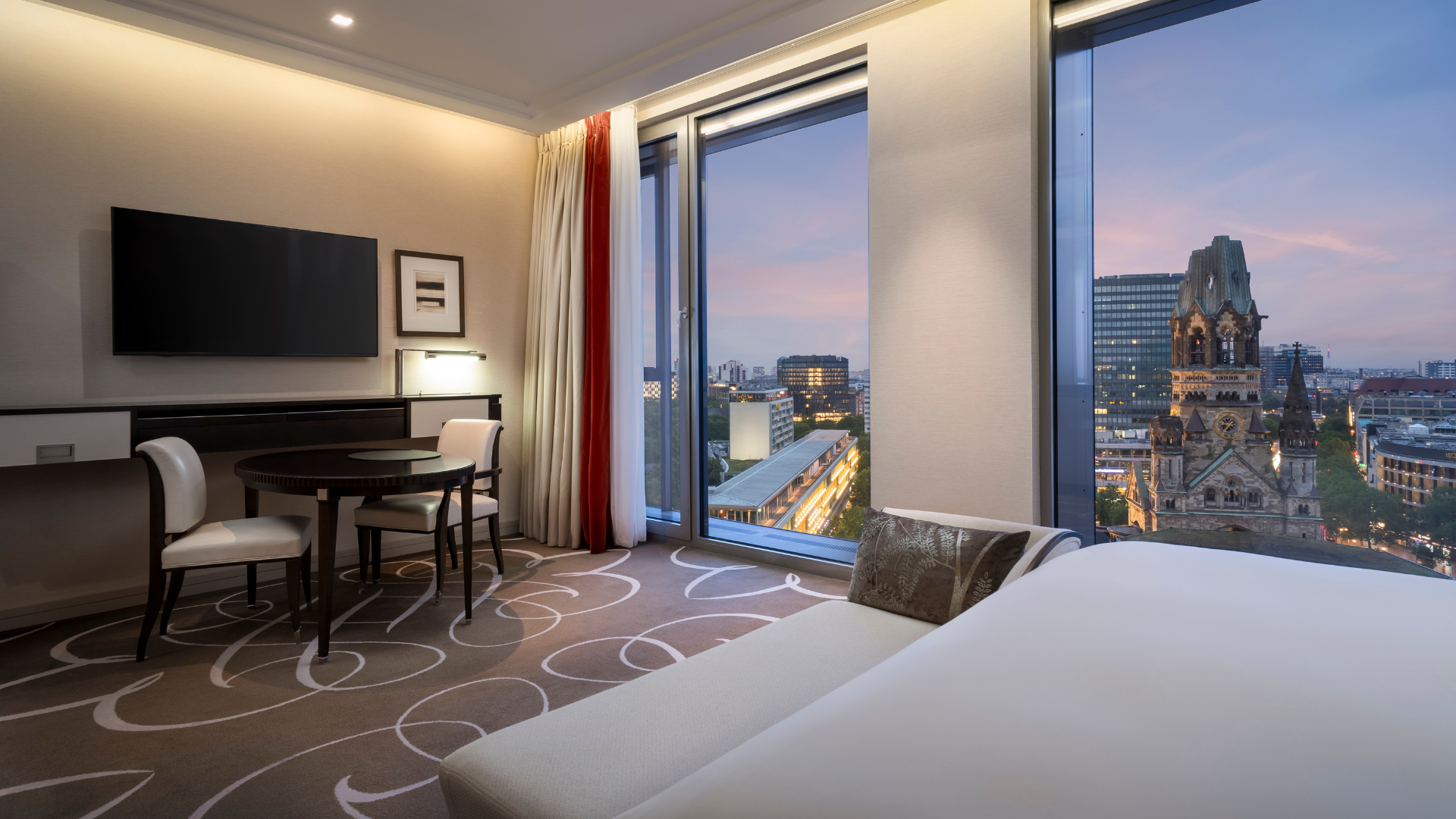 Hotelzimmer mit Fensterfront und Blick auf die Gedächtniskirche im Waldorf Astoria Berlin
