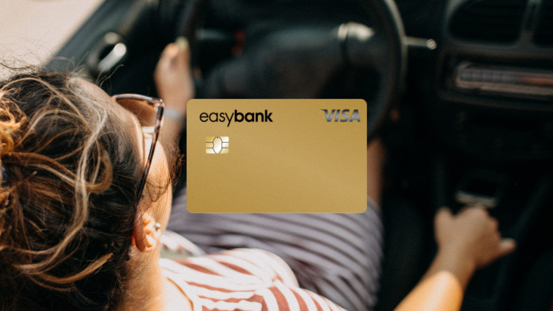 Easybank Gold im Vordergrund, im Hintergrund eine Frau beim Auto fahren