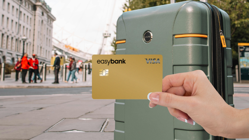 Easybank Gold im Vordergrund, im Hintergrund ein dunkelgruener Koffer