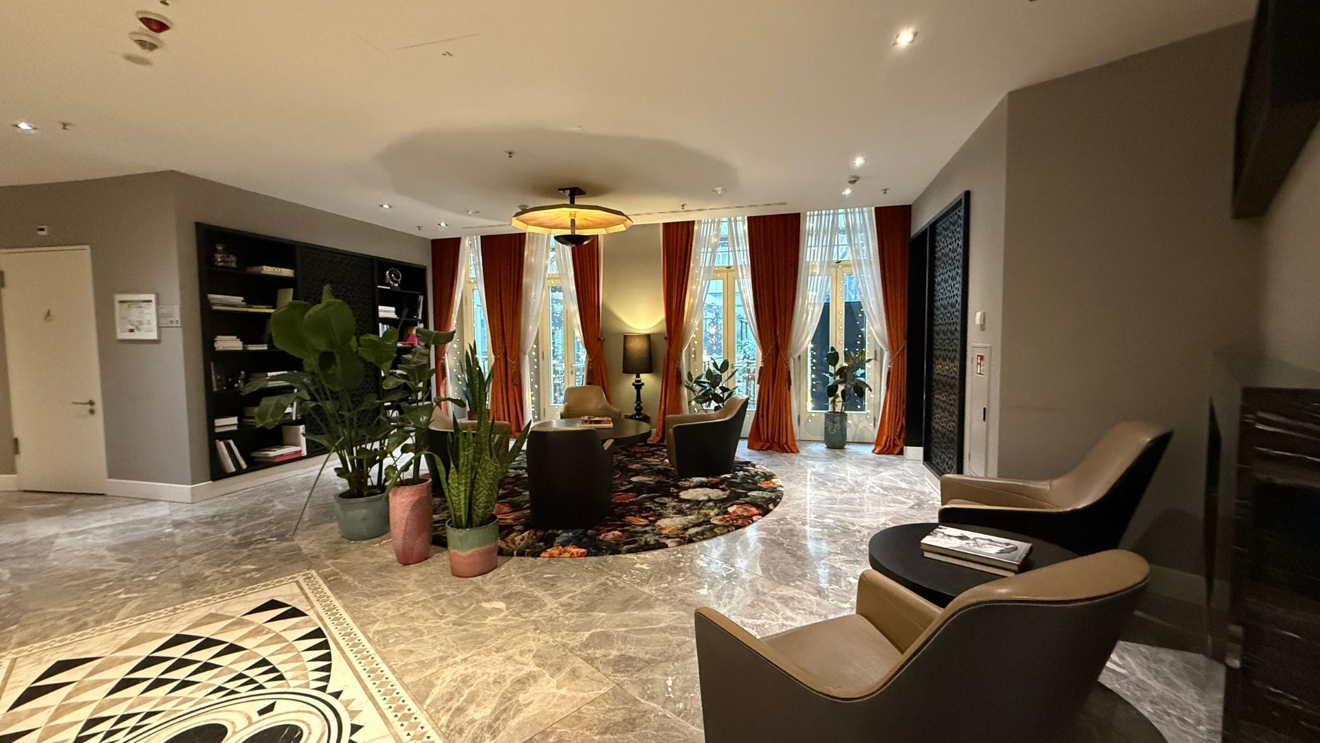Lobby des Roomers Berlin Steinplatz mit dunklem Holz und Sitzgruppen
