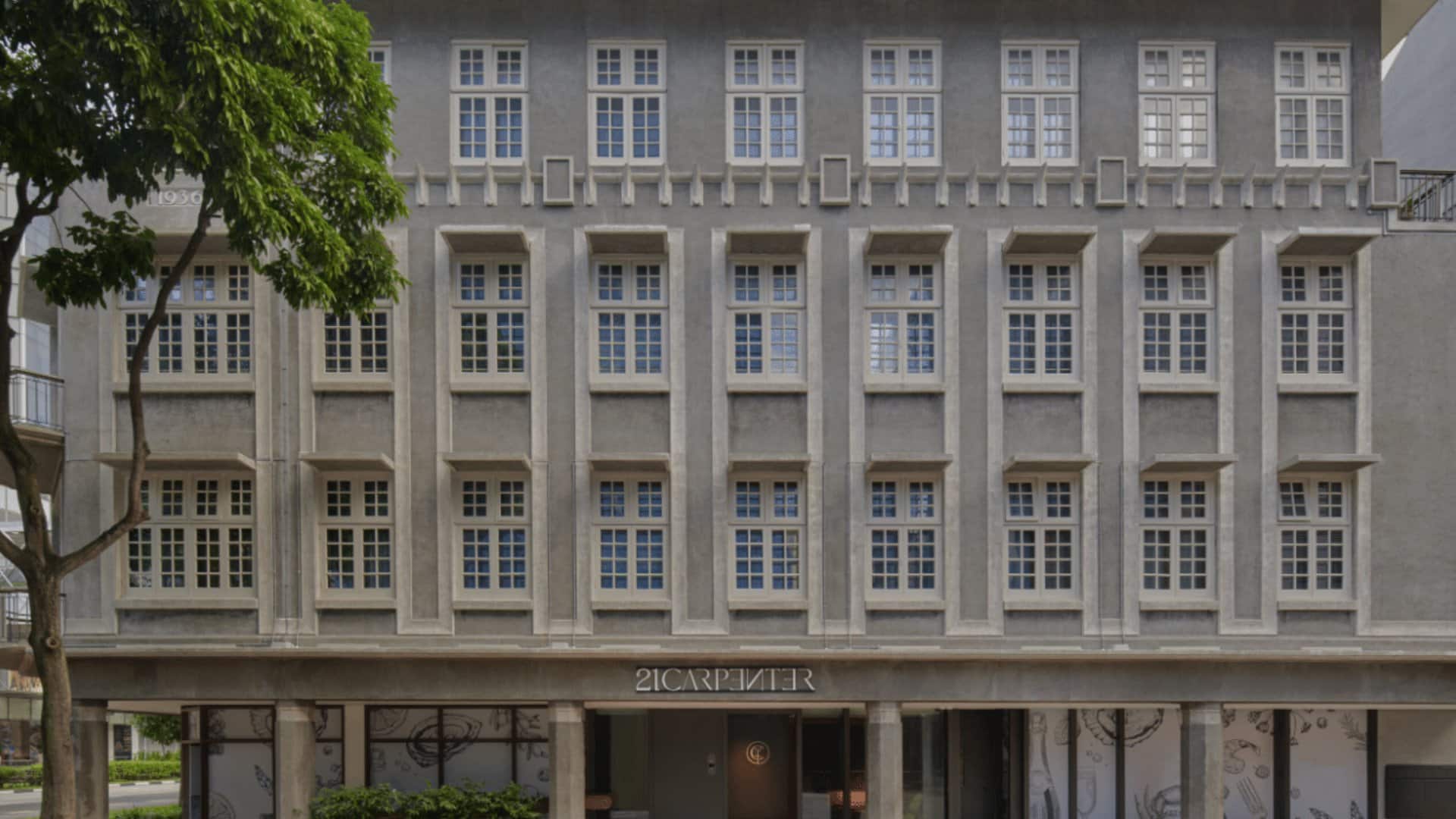 Fassade des 21 Carpenter in Singapur mit erhaltenem Putz und Rundbogenfenstern