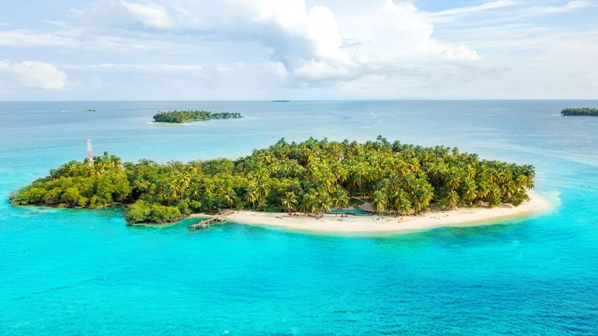 Luftaufnahme der Privatinsel Calala Island mit Palmen und tuerkisfarbenem Wasser