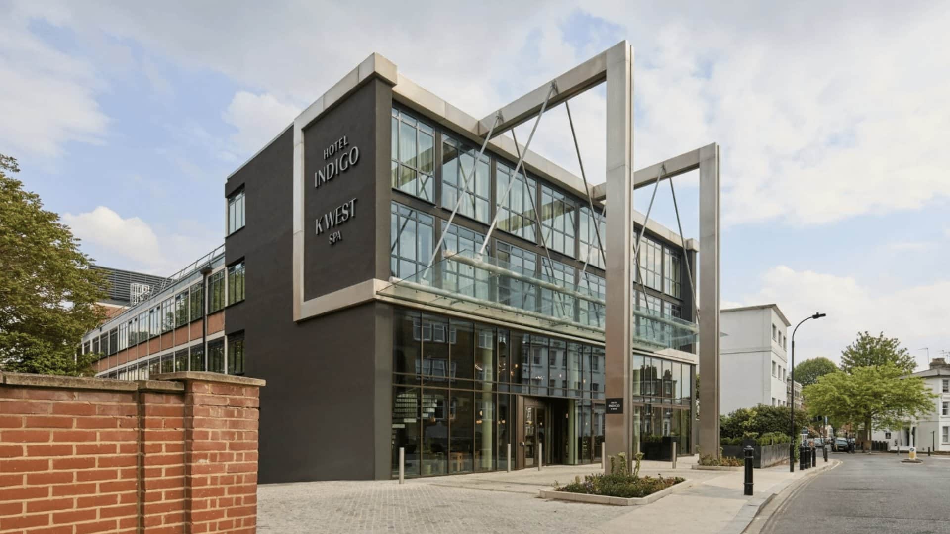 Fassade des Hotel Indigo London K West Shepherds Bush mit dunkler Verkleidung und verglastem Eingang