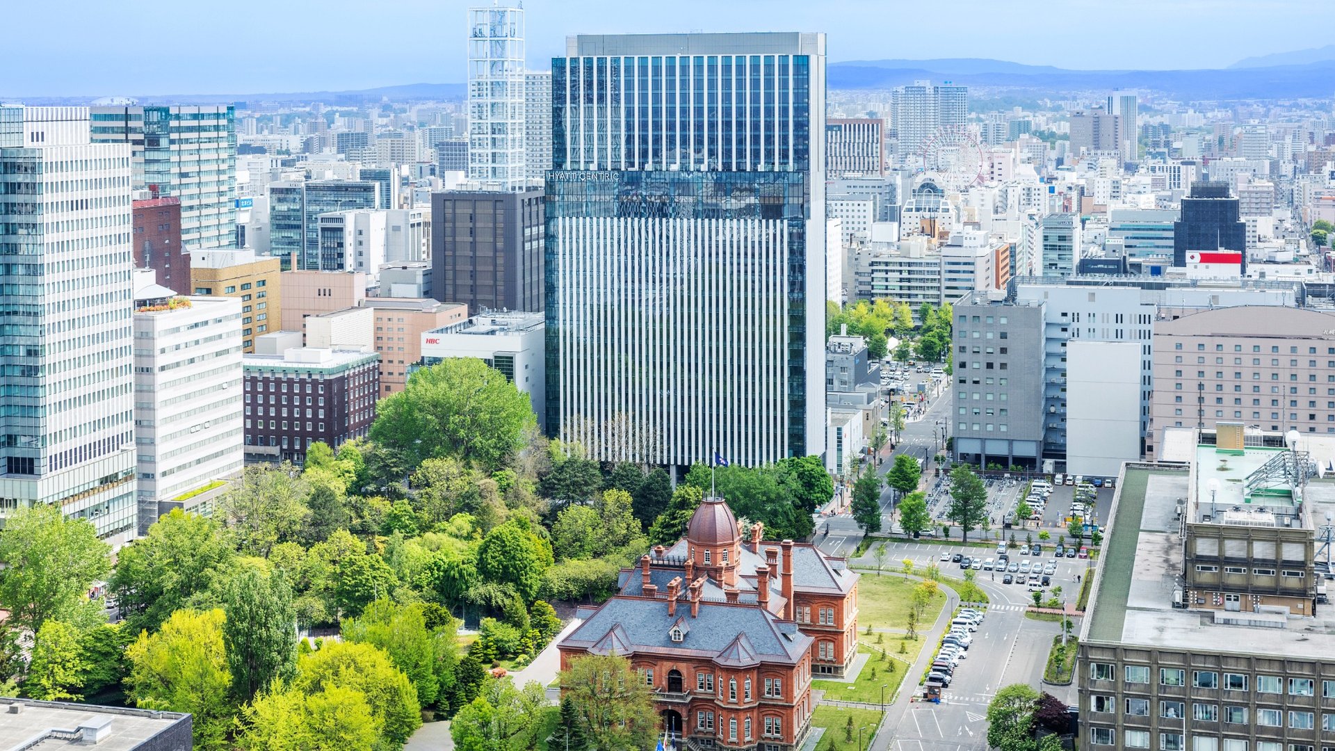 Hochhaus des Hyatt Centric Sapporo neben dem Roten Backsteingebaeude
